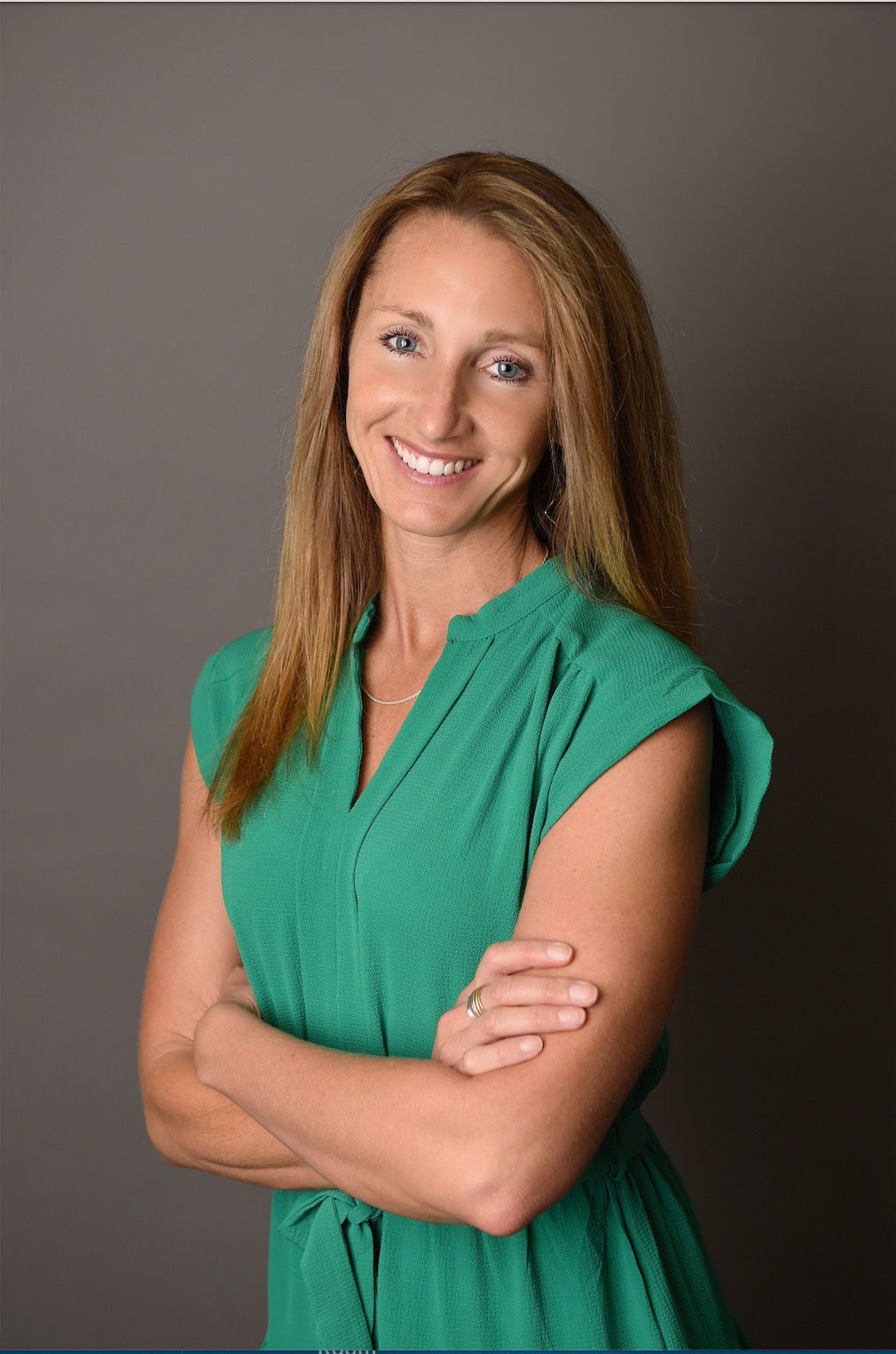 Ridgeline team member in a green dress on a gray studio background